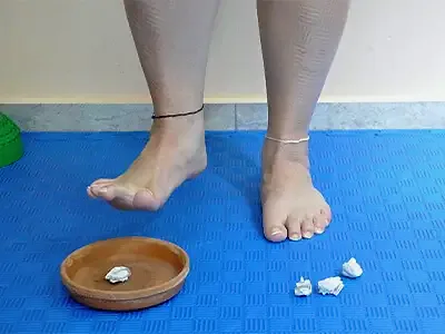 The foot carries the paper ball to the clay dish, with more paper balls beside it