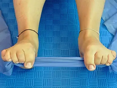 An exercise band looped around the toes of both feet, the feet about shoulder-width apart